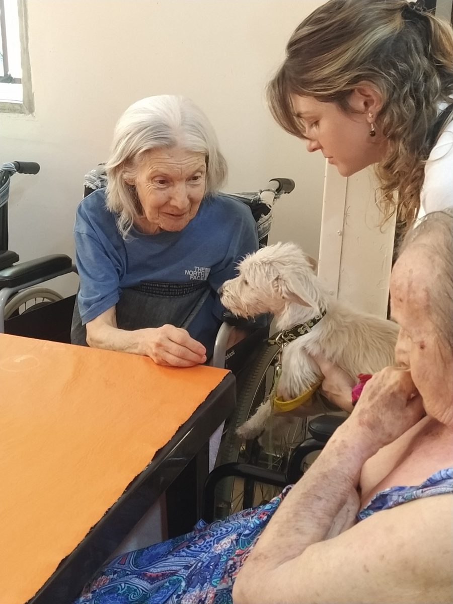 Encuentro entre una residente, personal y perro en una mesa compartida